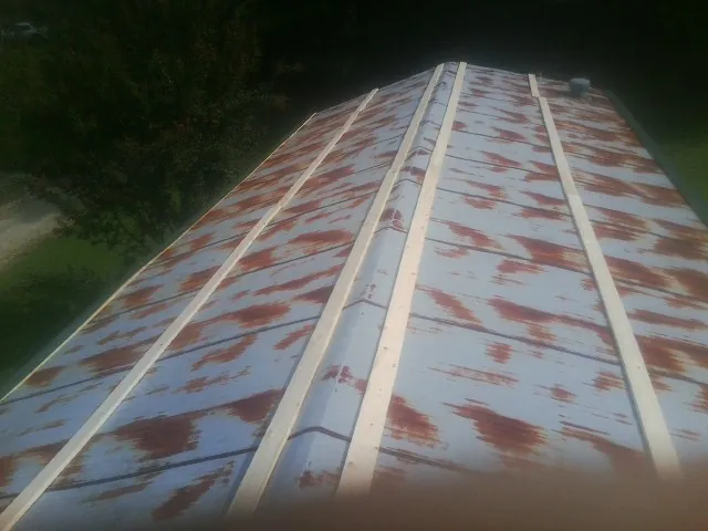 Rusted metal roof panels with new wood purlins before replacement — Storm Damage Roof Repair in Camillus by Roofing Brothers