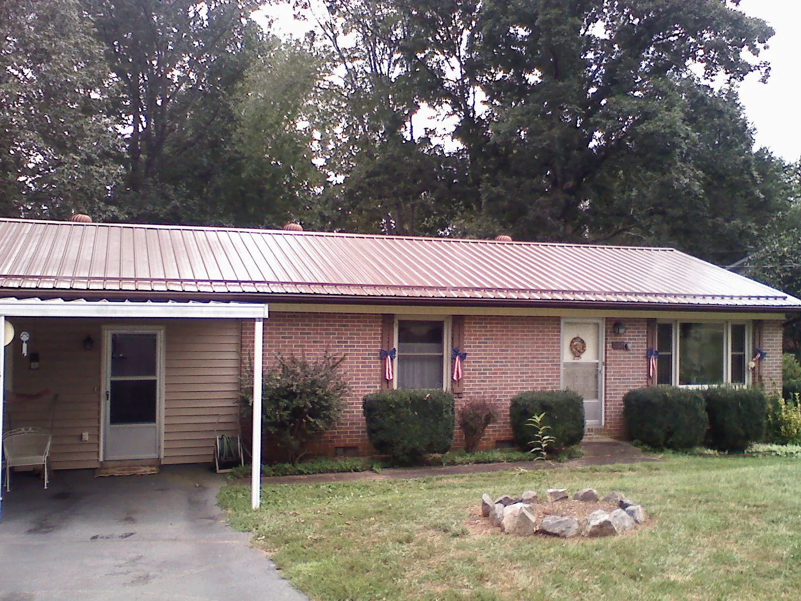 Bronze metal roof and carport on a brick ranch home — Roof Repair work by our crew in Camillus